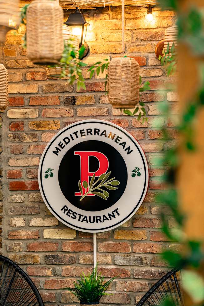 Pradas Mediterranean Restaurant sign under the terrace pergola